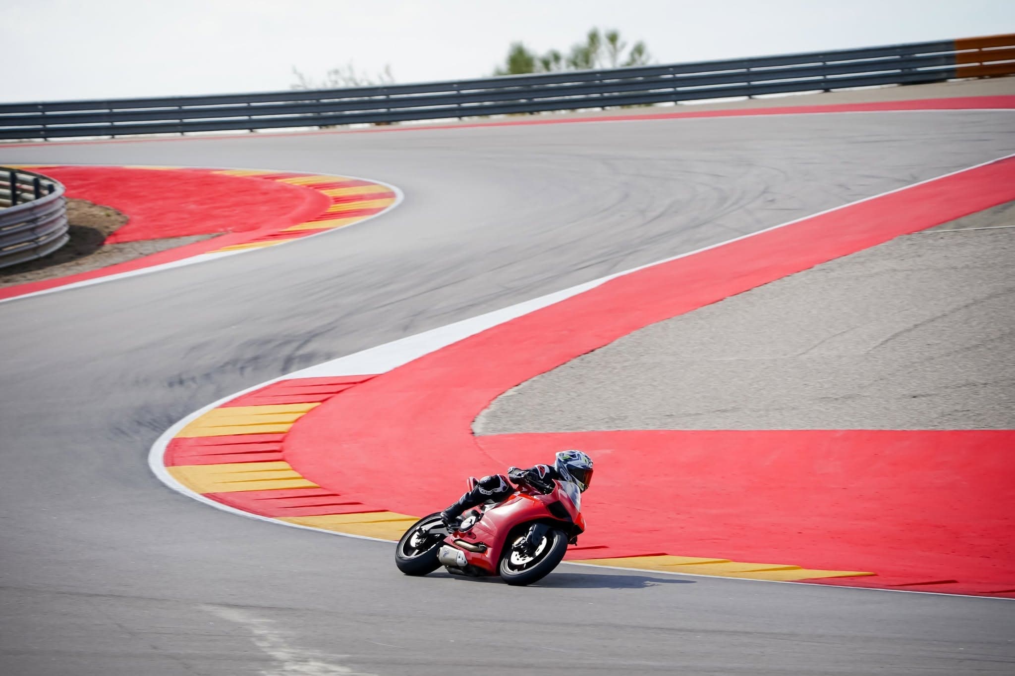 Red Ducati Panigale cranked over through a corner on track