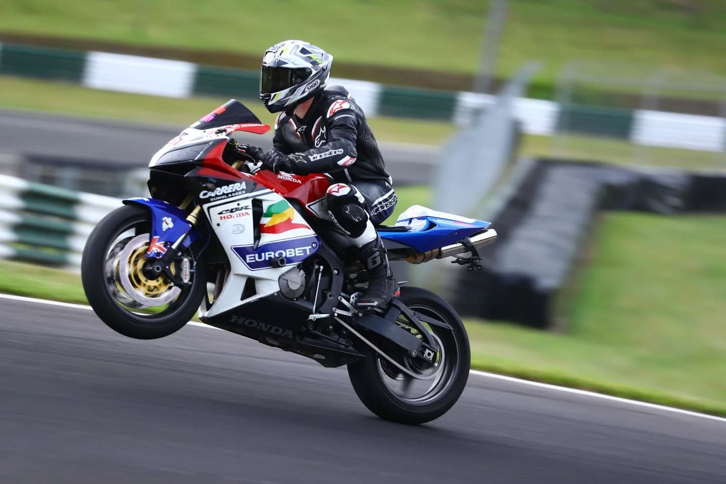 Rider pulling a wheelie on a Honda CBR at a UK track day